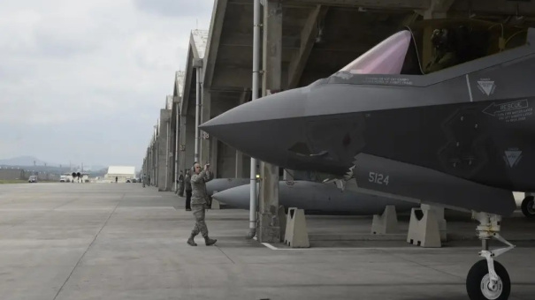 US Air Force Airman 1st Class Austin House, 388th Aircraft Maintenance Squadron crew chief, marshals an F-35A Lightning II from underneath a hardened facility on January 24, 2018, at Kadena Air Base, Japan. (US Air Force).